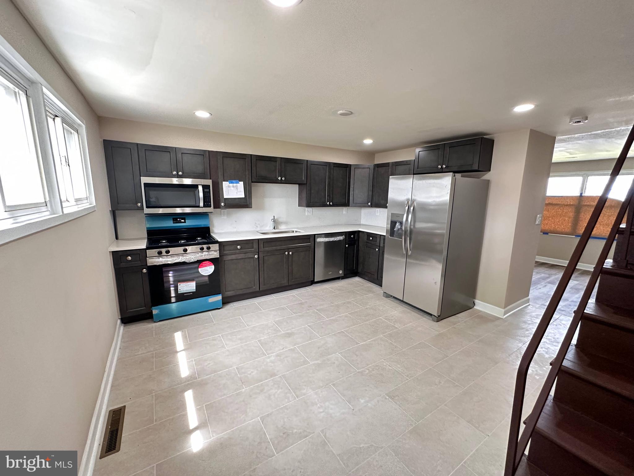 8039 Gough Street Baltimore, MD 21224 - Photo 6 of 17 a kitchen with stainless steel appliances granite countertop a refrigerator and a stove top oven