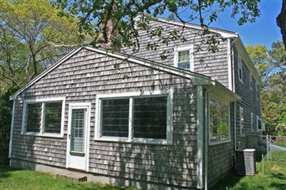 157 Poponessett Road Cotuit, MA 02635 - Photo 20 of 25 front view of a house with a garden