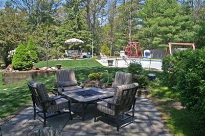 157 Poponessett Road Cotuit, MA 02635 - Photo 6 of 25 a view of a chairs and table in backyard