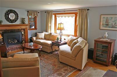 157 Poponessett Road Cotuit, MA 02635 - Photo 10 of 25 a living room with furniture a fireplace and a window