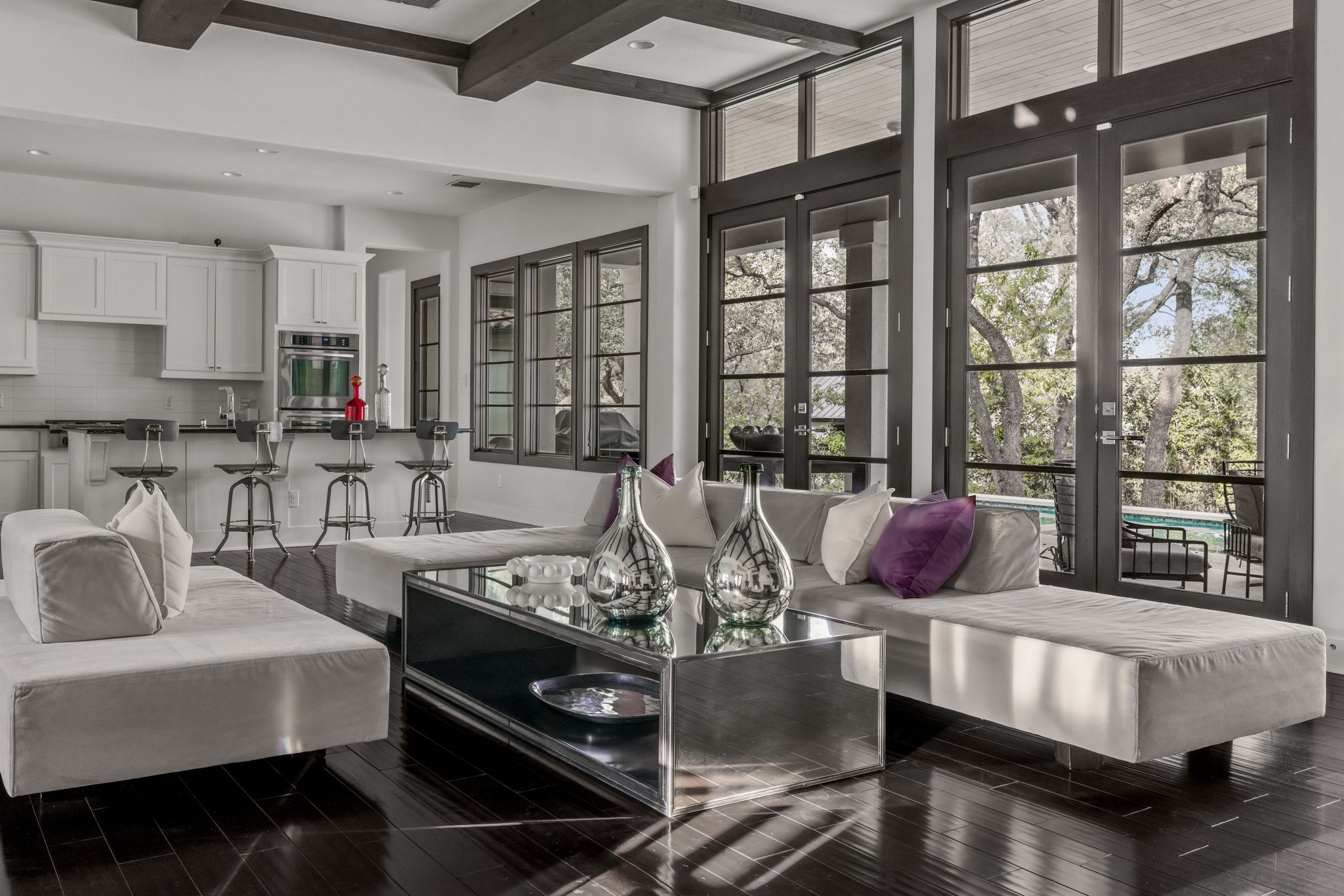 4720 Rockcliff Road, Unit 1 Austin, TX 78746 - Photo 8 of 39 An open concept living area boasts rich wood floors and large windows framing serene outdoor views.