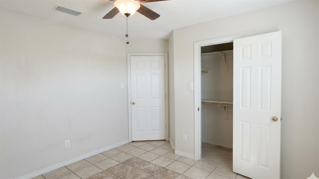 211 Vista Ridge Drive Venus, TX 76084 - Photo 19 of 24 Room featuring neutral wall tones, square tile flooring, a ceiling fan with integrated lighting, and a closet with shelving and hanging rods