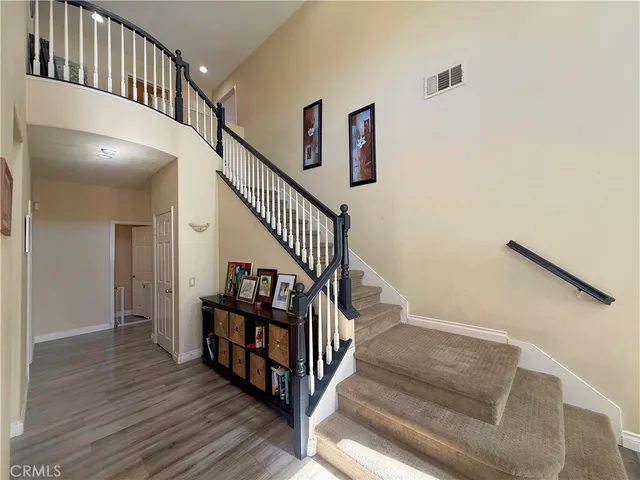a view of staircase with wooden floor and white walls