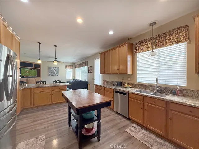 a kitchen with granite countertop a sink counter space cabinets stainless steel appliances and windows