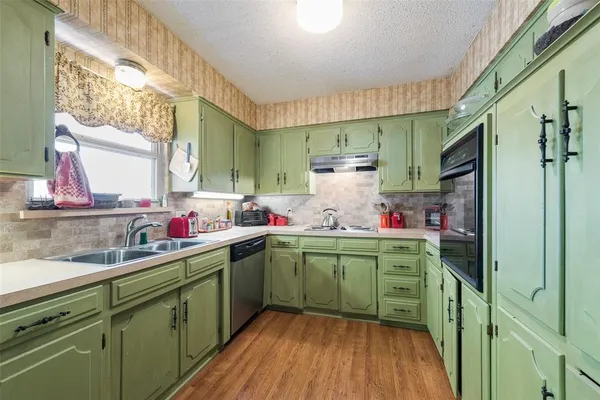 a kitchen with cabinets a window and stainless steel appliances