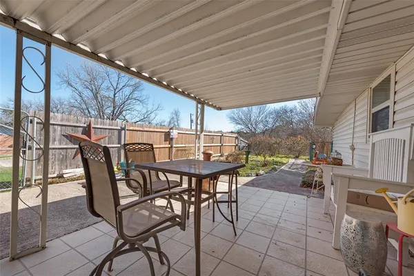 a view of a patio with table and chairs and potted plants
