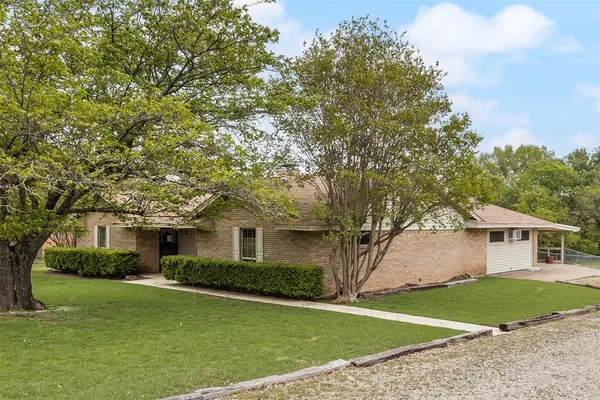 a front view of a house with a garden and yard