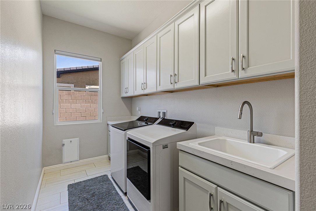 7036 Arabian Ridge Street Las Vegas, NV 89131 - Photo 33 of 64 Large Laundry room equipped with upper and lower cabinets, a sink, and an extra storage closet for.