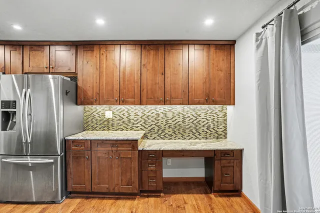 a kitchen with stainless steel appliances granite countertop a refrigerator and a stove