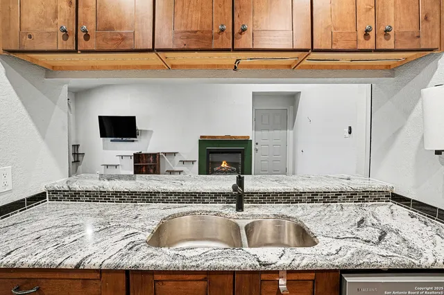 a view of a kitchen sink a faucet and a microwave