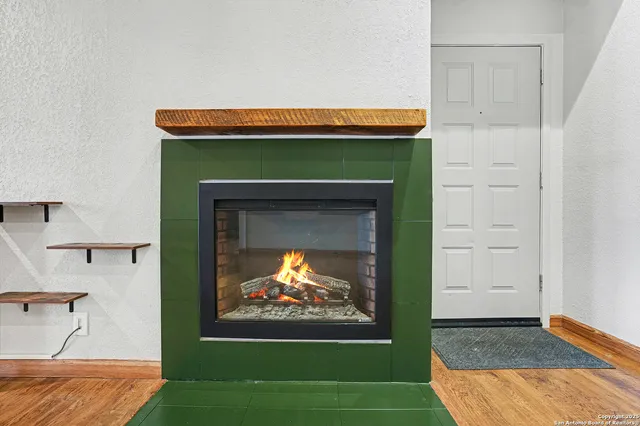 a living room with a fireplace and a open kitchen view