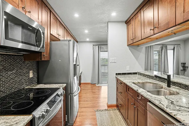a kitchen with granite countertop stainless steel appliances and wooden cabinets
