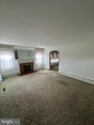 an empty room with fire place and windows