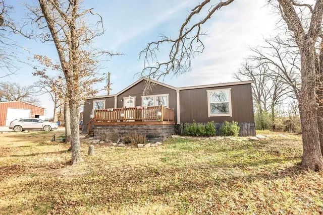 a front view of a house with a yard covered with snow
