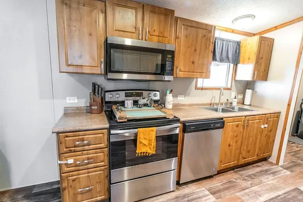 a kitchen with stainless steel appliances granite countertop a stove microwave and sink