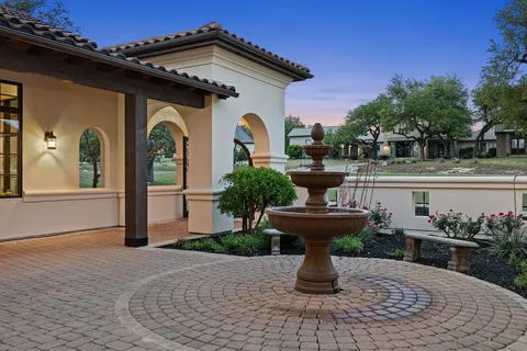 a view of a house with fountain in front of it