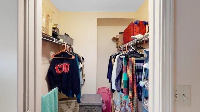 a view of walk in closet with clothes and shoes