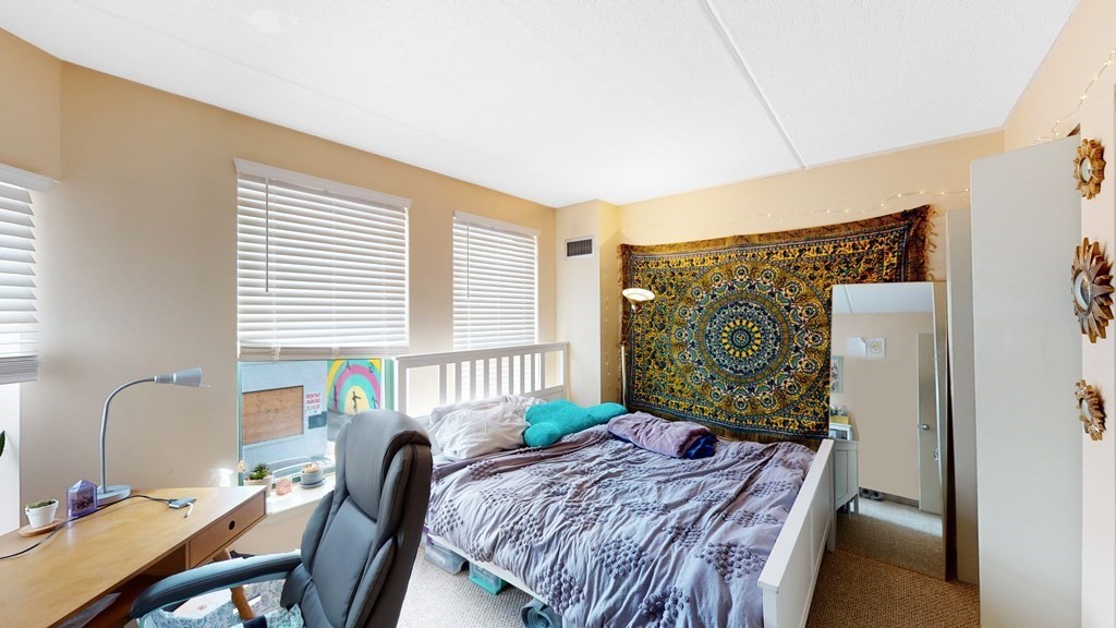108 Peterborough Street, Unit 3E Boston, MA 02215 - Photo 7 of 11 a bed sitting in a bedroom next to a window with computer on a desk
