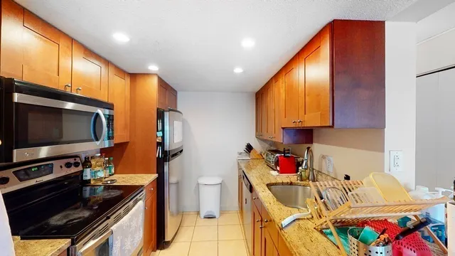 a kitchen with stainless steel appliances granite countertop a sink stove and cabinets