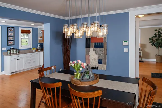 a dining room filled chandelier and wooden floor