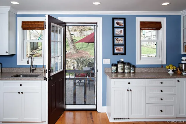 a kitchen with granite countertop a sink cabinets stainless steel appliances and a window