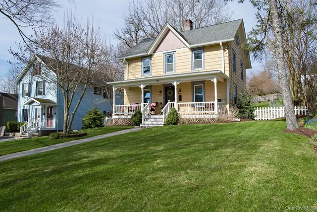 a front view of a house with a garden and trees