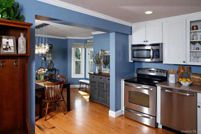 a kitchen with a stove a microwave and wooden floor