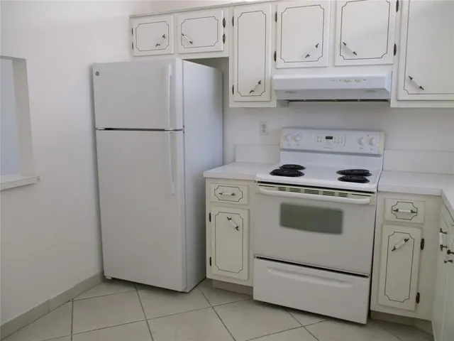 a kitchen with white cabinets and white appliances