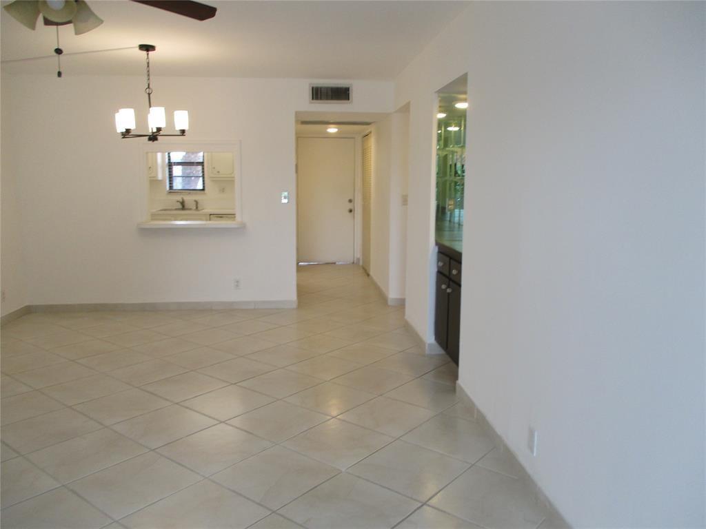 9233 Southwest 8th Street, Unit 311 Boca Raton, FL 33428 - Photo 6 of 19 an empty room with kitchen view and hallway