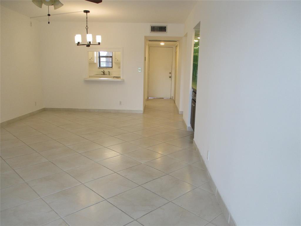9233 Southwest 8th Street, Unit 311 Boca Raton, FL 33428 - Photo 9 of 19 en empty room with wooden floor and chandelier