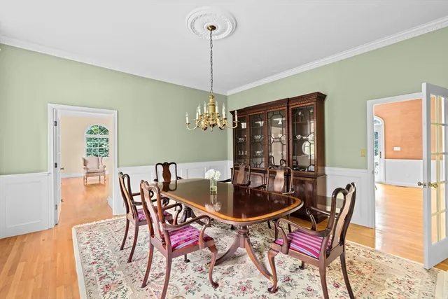 a dining room with furniture a chandelier and wooden floor