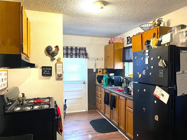 a kitchen with stainless steel appliances kitchen island granite countertop a stove a sink and a refrigerator