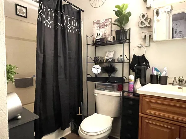 a bathroom with a toilet and a shower curtain