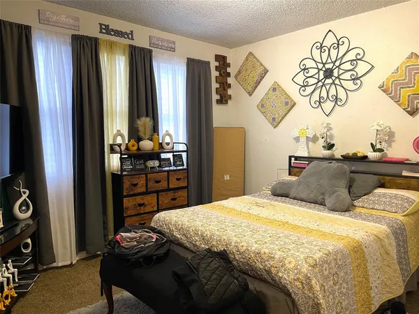 a bedroom with a bed a dresser and a window