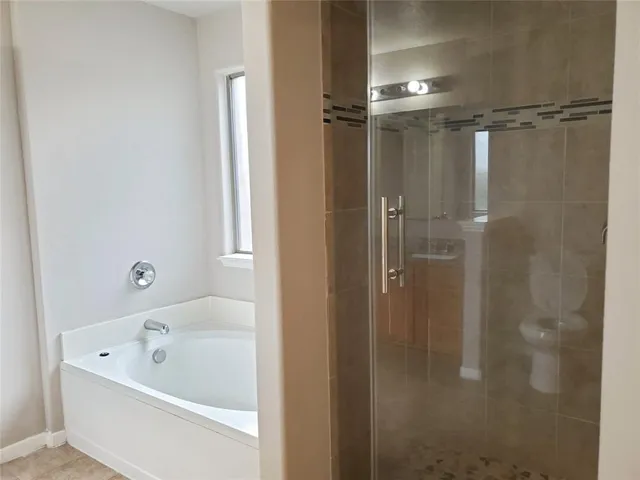 a bathroom with a tub shower and a sink