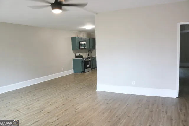 a view of empty room with wooden floor