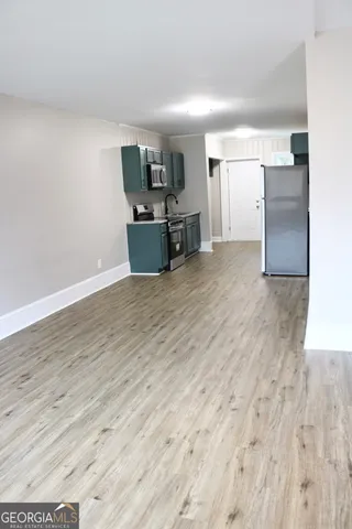 a view of a kitchen with a sink and a refrigerator