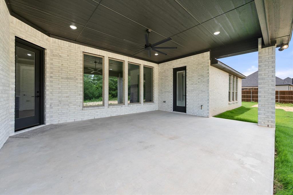 6610 Waggoner Way Midlothian, TX 76065 - Photo 38 of 40 Expansive covered patio featuring a concrete surface, white brick exterior, black ceiling with recessed lighting, and a ceiling fan
