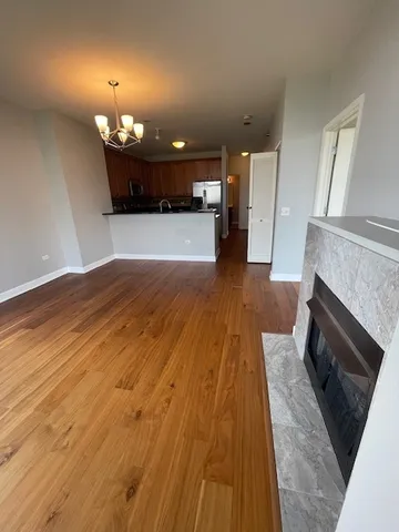an empty room with wooden floor a fireplace and entryway