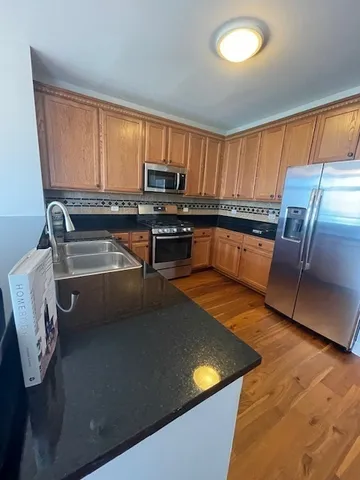 a kitchen with stainless steel appliances granite countertop a stove a sink and a microwave