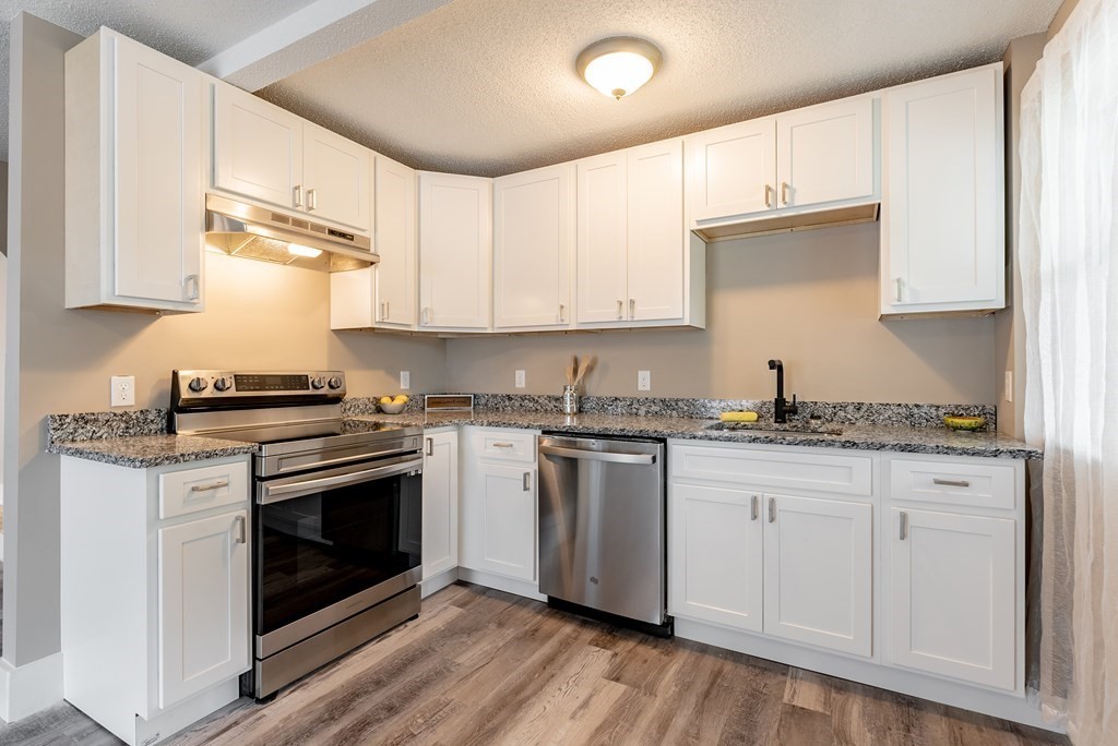 37 North Street Three Rivers, MA 01080 - Photo 4 of 35 a kitchen with granite countertop wooden cabinets stainless steel appliances and a wooden floor