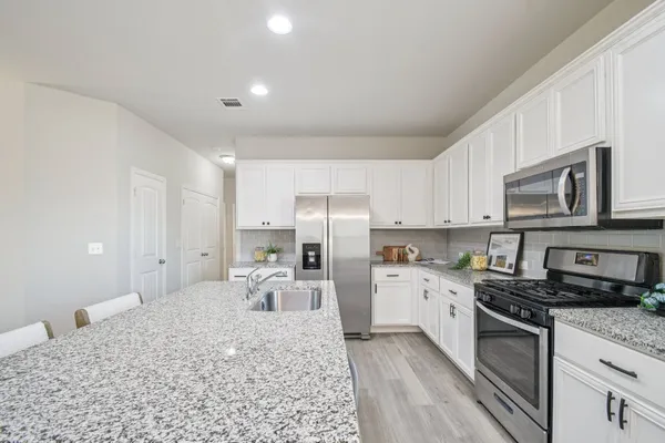 a kitchen with granite countertop a sink stainless steel appliances and cabinets