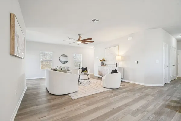 a living room with furniture and a wooden floor