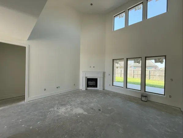 a view of an empty room with a fireplace and a window