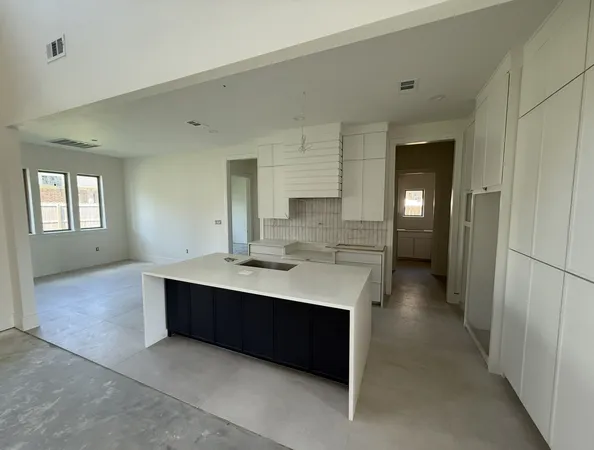a view with cabinets a sink dishwasher and a refrigerator in a kitchen