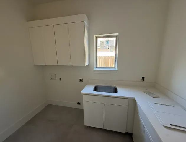 a utility room with sink dryer and washer