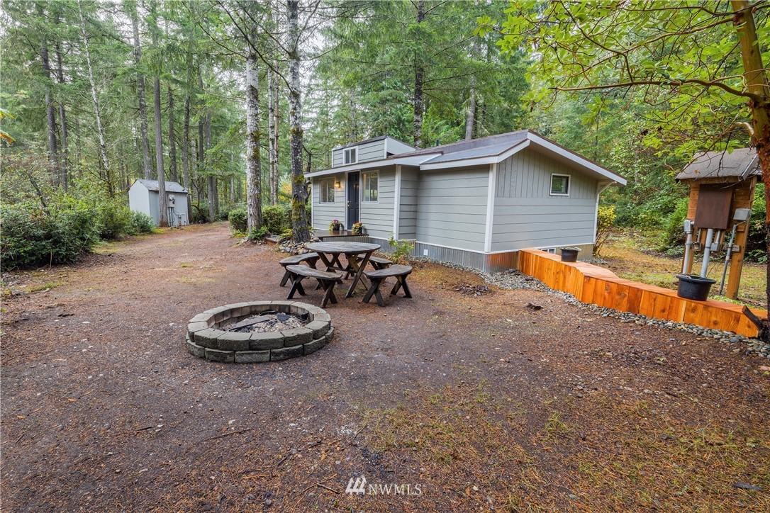 26 Webb Road Southwest Lakebay, WA 98349 - Photo 6 of 31 a backyard of a house with table and chairs a barbeque