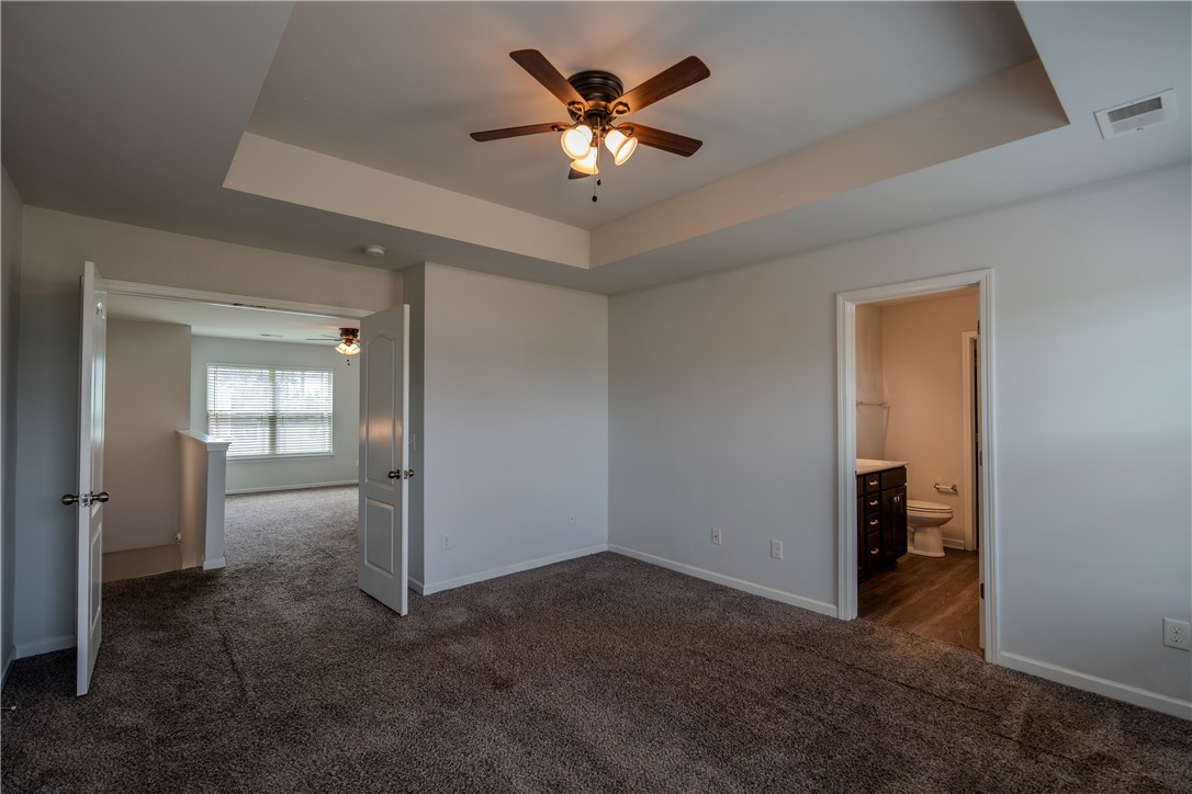 102 Talisker Way Greenville, SC 29607 - Photo 15 of 18 An inviting bedroom offers a tranquil retreat with a private bathroom and an adjacent versatile space.
