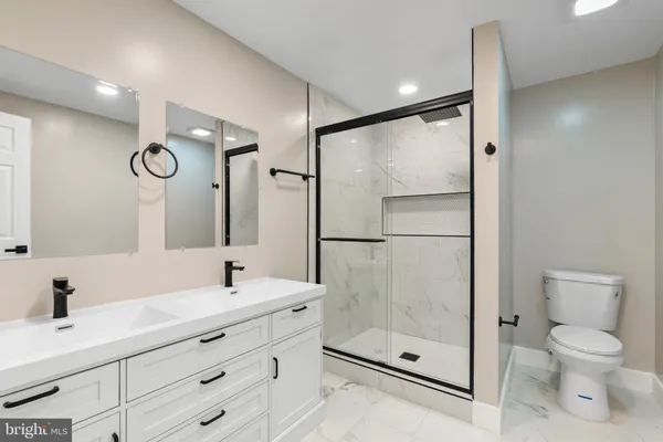a bathroom with a shower sink mirror and toilet