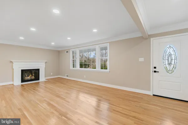 an empty room with windows and fireplace